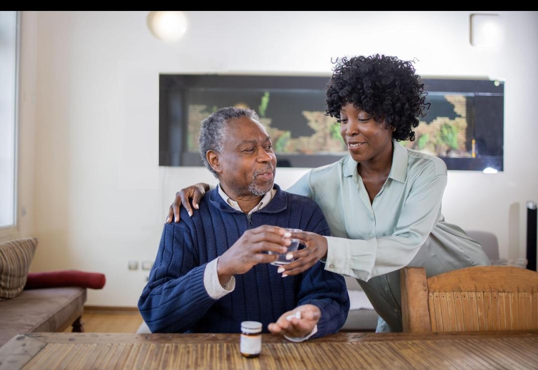 Nurse helping elderly patient with medication